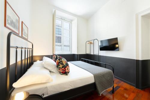 ein Schlafzimmer mit einem schwarz-weißen Bett und einem Fernseher in der Unterkunft Salotto Borbonico - Sanfelice in Neapel