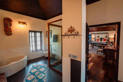 a bathroom with a tub and a mirror at Madilina Heritage Villa in Parūr