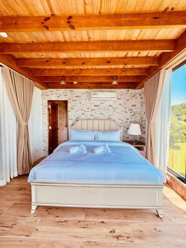 a bedroom with a large bed with a wooden ceiling at Sangria-Luna Resort and Hotel in Luna