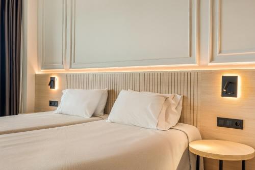 a hotel room with a bed with white pillows at Hotel Miramar in Lloret de Mar