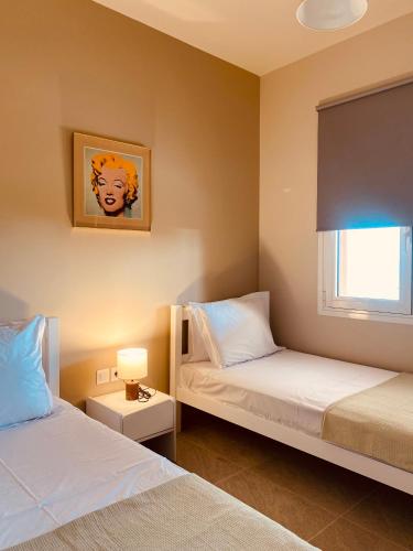 a bedroom with two beds and a window at Villa Banana in Lourdata