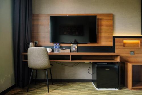 a room with a desk with a television and a chair at NB HOTEL in Johor Bahru