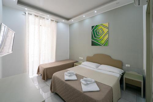 a hotel room with two beds with towels on them at Royal House Napoli Centro, by ClaPa Group in Naples