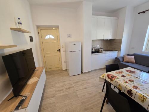 a kitchen and living room with a couch and a table at Nian Apartments in Vlorë