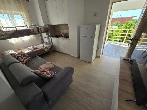 a living room with a couch and a refrigerator at Nian Apartments in Vlorë