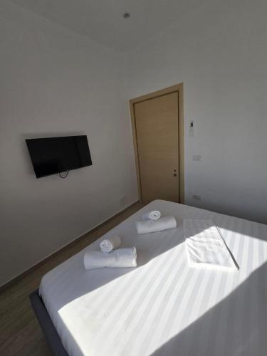 a bedroom with a bed with two towels on it at Nian Apartments in Vlorë