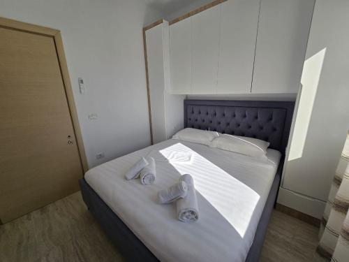 a bedroom with a bed with two towels on it at Nian Apartments in Vlorë