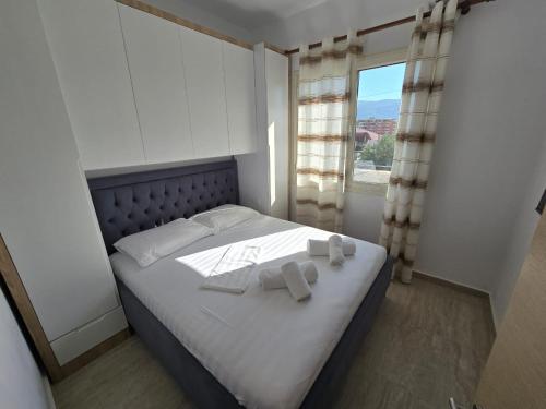 a bedroom with a bed with two towels on it at Nian Apartments in Vlorë