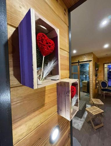 une pièce avec un mur en bois avec des coeurs rouges dans une boîte dans l'établissement Chambre confortable, à Saint-Amand-les-Eaux