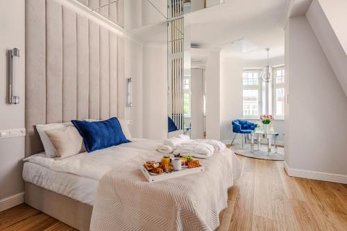 a bedroom with a bed with a tray of food on it at Bałtyk Residence Międzyzdroje, BASEN, SAUNA Apartamenty 2,3,4 os z jacuzzi in Międzyzdroje