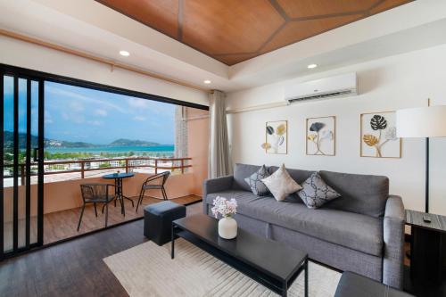 a living room with a couch and a balcony at Enjoy Sunset Rainbow Alley - WOW Townhouse at Patong Hill in Patong Beach