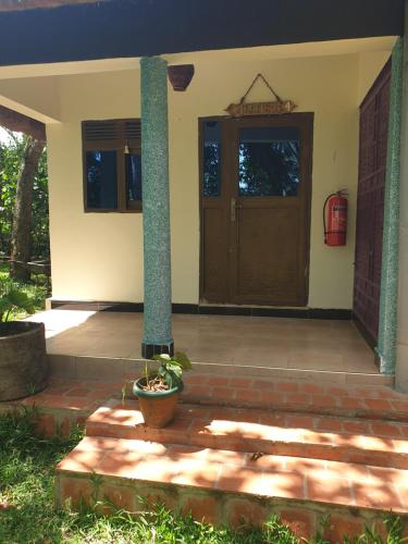 a front door of a house with a potted plant at Nguru Farm in Kabale