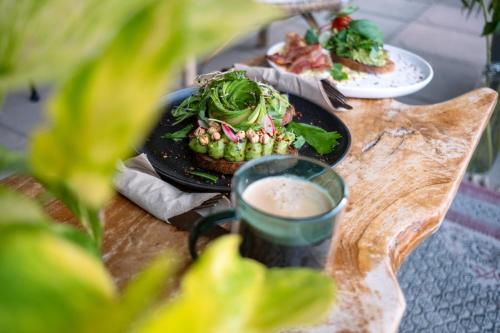 a table with two plates of food and a cup of coffee at Room's at HAUS am SEE direkt am Thunersee gelegen mit SELF CHECK IN & digitaler Rezeption in Oberhofen am Thunersee