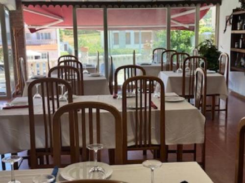 rząd stołów i krzeseł w restauracji w obiekcie Hostal Restaurante Pinarejo w mieście A Lanzada