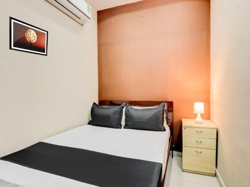 a small bedroom with a bed and a night stand at HOTEL O ORR RESIDENCY in Hyderabad