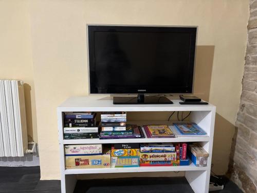 a white entertainment center with a tv and books at Lydie in Pressigny