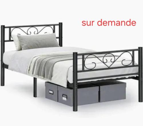 a bed with a black frame and white sheets at Lydie in Pressigny