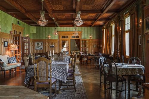 una sala da pranzo con tavoli e sedie e pareti verdi di Skogsbrynet B&B, Bredsjö Nya Herrgård a Hällefors