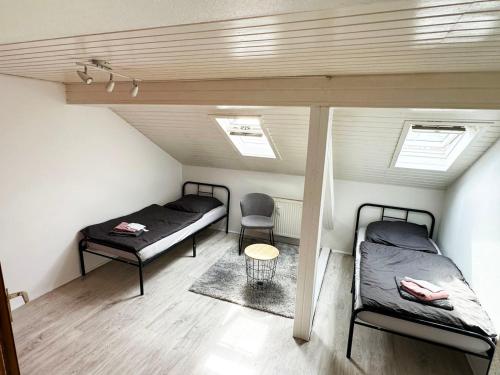 a room with two beds and a chair in it at Comfort Stay Apartment in Rüsselsheim am Main in Rüsselsheim