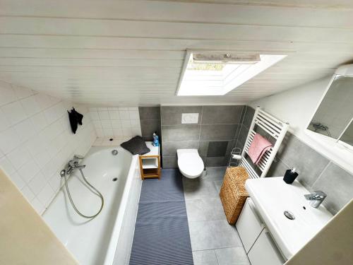 a bathroom with a tub and a toilet and a sink at Comfort Stay Apartment in Rüsselsheim am Main in Rüsselsheim