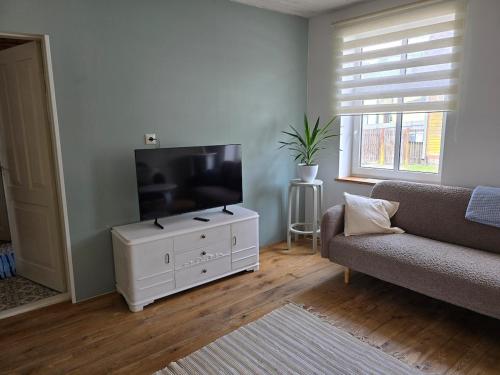 a living room with a flat screen tv on a white cabinet at Suur-Veski apartement in Pärnu