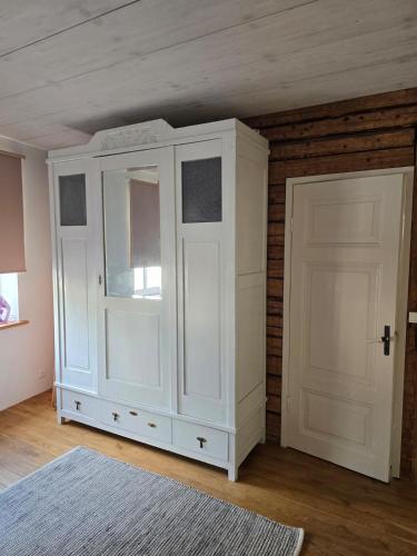 a white cabinet and a door in a room at Suur-Veski apartement in Pärnu