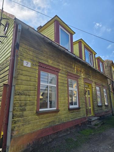 a yellow house with red windows at Suur-Veski apartement in Pärnu