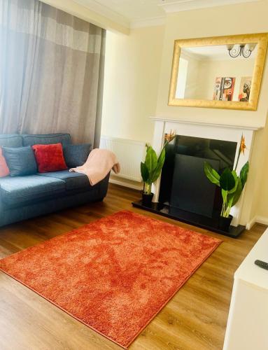a living room with a blue couch and a television at Ace Space 2 in Stifford