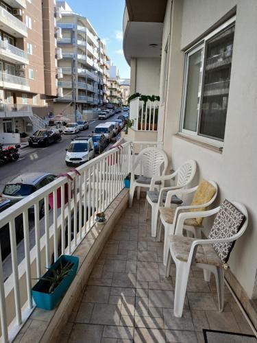 a balcony with chairs and a view of a street at Spacious 3 Bedroom Apt Near the Sea in St Paul's Bay