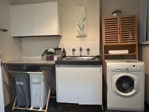 a kitchen with a sink and a washing machine at 3 Bdrm home,pool, BBQ , fireplace Great for a weekend of fun or family retreat in Croydon