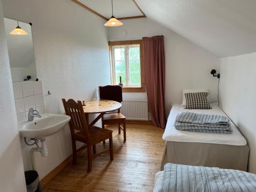 a room with a sink and a bed and a table at Humletorkan Vandrarhem in Näsum