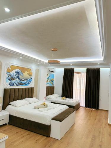a bedroom with two beds and a painting on the wall at Bamisa apartamets in Golem
