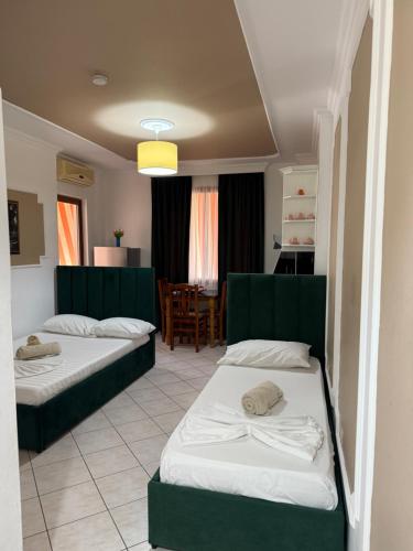 a hotel room with two beds and a table at Bamisa apartamets in Golem