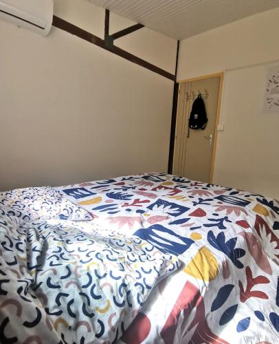 a bed with a colorful comforter in a bedroom at KaZandoli in Les Anses-dʼArlets