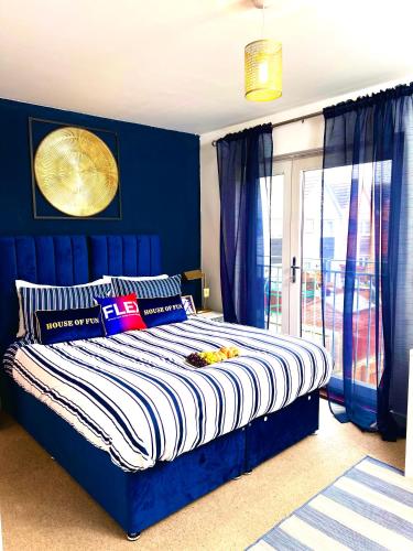ein Schlafzimmer mit einem Bett mit blauen Wänden in der Unterkunft 5 Bedroom Contractors Accommodation in Dartford Kent - Spacious Holiday Home - Close To Dartford Crossing - Close To City Centre in Dartford