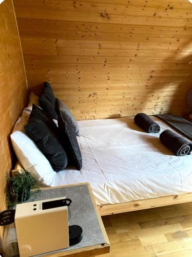 a bed in a wooden room with a laptop on a table at Apple Tree Cabin in Mitchel Troy