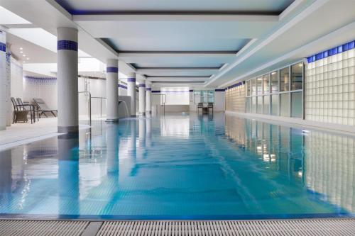 a swimming pool with blue water in a building at Hilton Cardiff in Cardiff