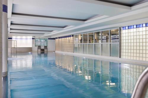 a large swimming pool with blue water in a building at Hilton Cardiff in Cardiff