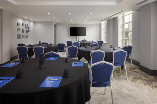 a conference room with tables and chairs and a tv at Hilton Cardiff in Cardiff