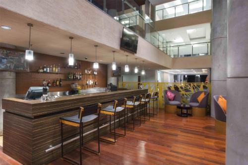 a bar with a bunch of stools in a restaurant at Hilton Garden Inn Bali Ngurah Rai Airport in Kuta