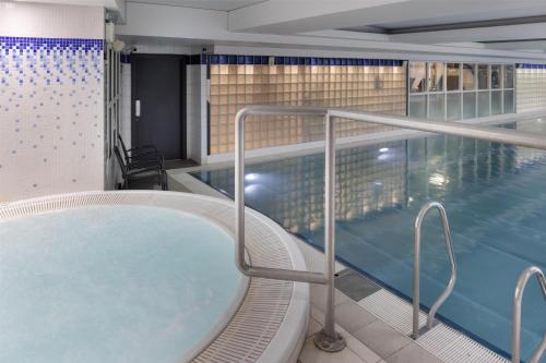 a swimming pool with a hot tub in a building at Hilton Cardiff in Cardiff