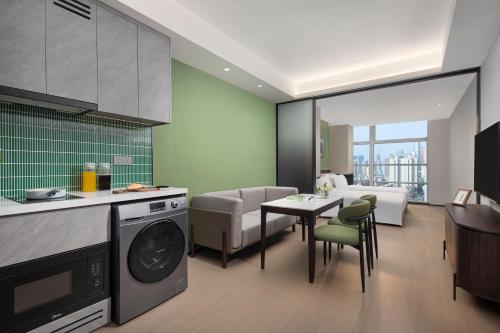 a kitchen and living room with a washing machine at Modena By Fraser Shenzhen in Shenzhen