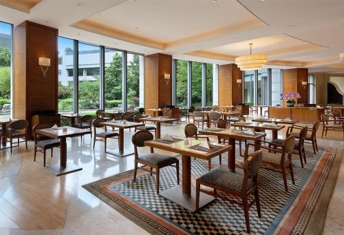 a restaurant with tables and chairs and windows at DoubleTree by Hilton Shanghai Pudong - Present welcome cookie in Shanghai