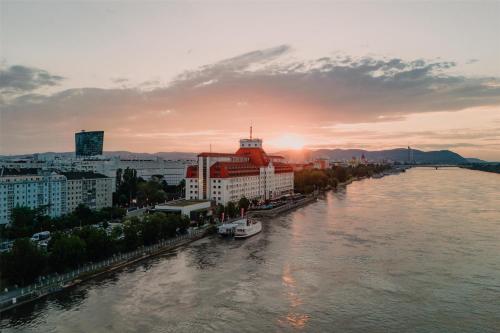 a view of a river with buildings and a city at Hilton Vienna Waterfront in Vienna