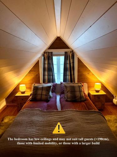 a bedroom with a large bed in a attic at Unique 200-year old tiny house in Old town in Stavanger