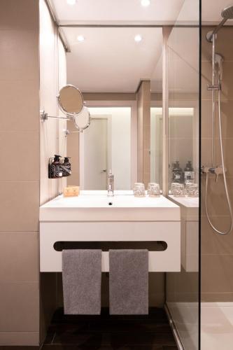 a bathroom with a white sink and a shower at INNSiDE by Meliá Alicante Porta Maris in Alicante