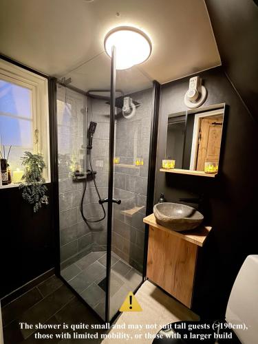 a bathroom with a shower and a sink at Unique 200-year old tiny house in Old town in Stavanger