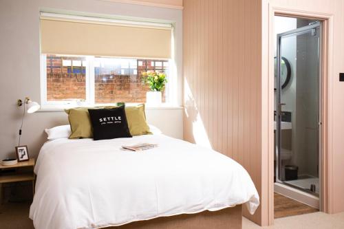 a bedroom with a white bed and a window at Settle Southampton - Stylish Self Check-In Rooms & Self Catering Suites in Southampton