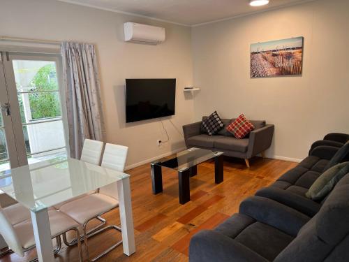 a living room with a couch and a table at Central Spacious House With Backyard And Patio in Palmerston North