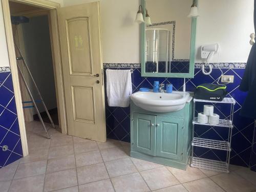 a blue bathroom with a sink and a mirror at Giulieda in Sunshine in Sanfatucchio